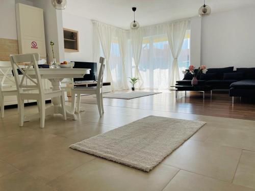a living room with a white table and chairs at Galaxy Residence Villa in Otopeni