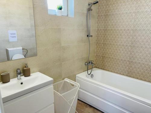 a bathroom with a sink and a tub and a toilet at Galaxy Residence Villa in Otopeni
