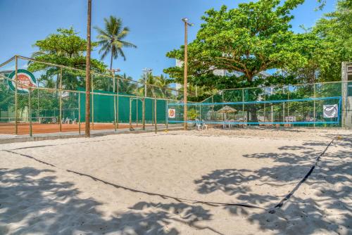 a tennis court with a fence and a volleyball court at Ritz Lagoa da Anta Hotel & SPA in Maceió