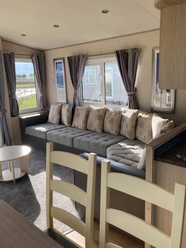 a living room with a couch and some windows at The Blue Beachcomber in Chapel Saint Leonards