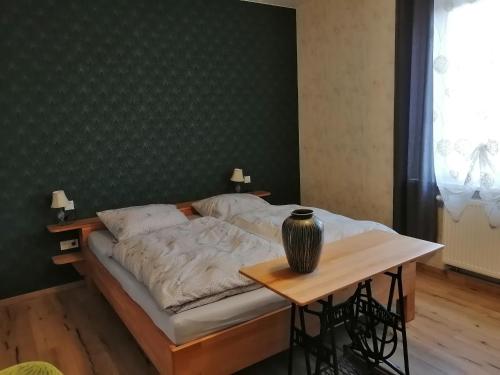 a bedroom with a bed and a table with a vase on it at alte Apotheke in Roßdorf