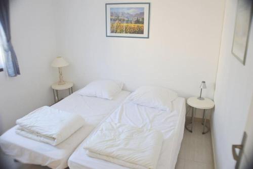 ein weißes Zimmer mit 2 Betten und 2 Tischen in der Unterkunft BEL APPARTEMENT 2 PIECES A 200m DES PLAGES in Cavalaire-sur-Mer