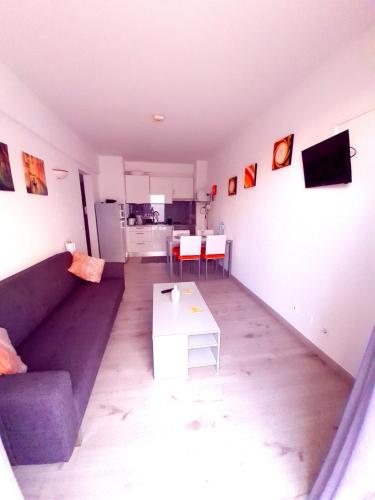 a living room with a purple couch and a table at Apartamentos Julieta in Albufeira