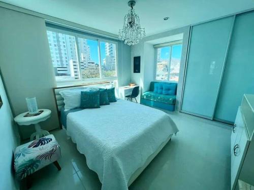 a bedroom with a large bed and a chandelier at Apartamento exclusivo en Santa Marta cerca al mar in Gaira