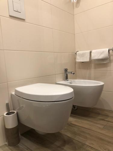 a bathroom with a white toilet and a sink at ZEROstuni suite apartment in Ostuni