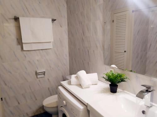 ein Badezimmer mit einem Waschbecken, einem WC und einem Spiegel in der Unterkunft Cheap & Chic Apartamentos en Son Bou de 2 dormitorios in Son Bou