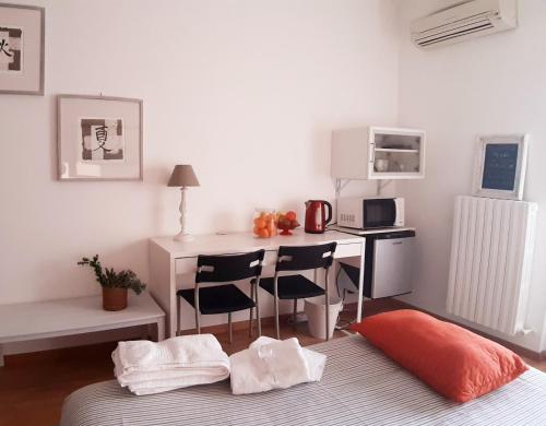 My b&b - Strada Vecchia del Pinocchio 3/B في أنكونا: غرفة نوم مع مكتب وسرير مع كراسي