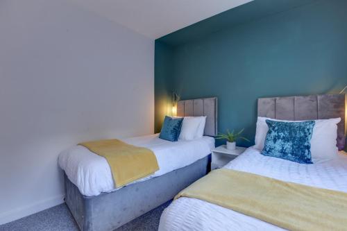 2 camas en una habitación con paredes azules en Central Chelmsford - Two Bed flat with Parking - Free Wifi and Netflix en Chelmsford