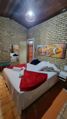 a bedroom with two large beds with red sheets at Chalé 17 - Porto do Sol - Pipa in Pipa