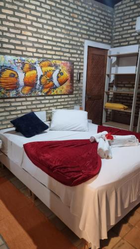 a large bed in a room with a painting on the wall at Chalé 17 - Porto do Sol - Pipa in Pipa