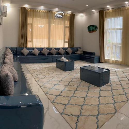 una gran sala de estar con sofá y mesas. en The Palace Chalet en Salalah