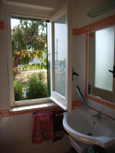 a bathroom with a sink and a window with a view at Marasusa in Parghelia