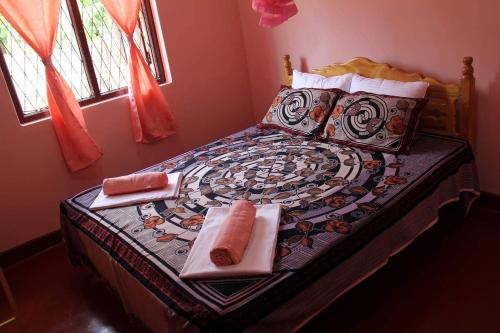 a bedroom with a bed with two towels on it at Batti Relax Point in Batticaloa