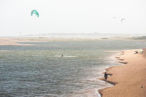 a man standing on a beach flying a kite at Posada Paradiso in José Ignacio