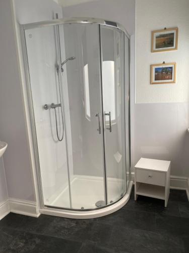 a shower with a glass door in a bathroom at Park View Hotel and Guest House in Thatto Heath