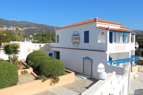 a white house with a sign on the side of it at Pavlis Studios Ormos in Marathokampos