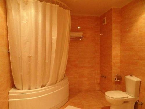 a bathroom with a white toilet and a shower at Patio suite, Porto marina in El Alamein