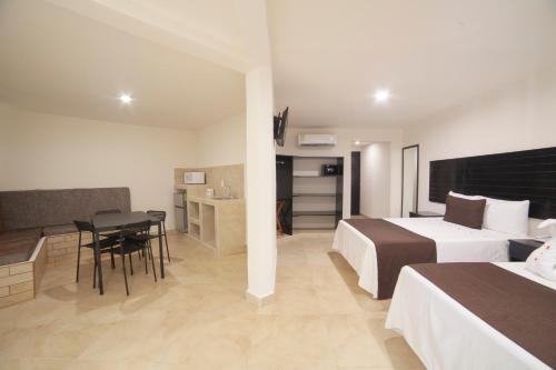 サンタ・クルス・ウアトゥルコにあるMayev Expressのベッド2台、テーブルと椅子が備わるホテルルームです。