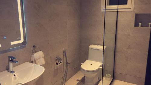 a bathroom with a toilet and a sink at Voyage Apartments in Riyadh