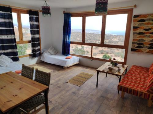 達卡扎特的住宿－Taghazout Hill Retreat，客厅配有两张床和一张桌子