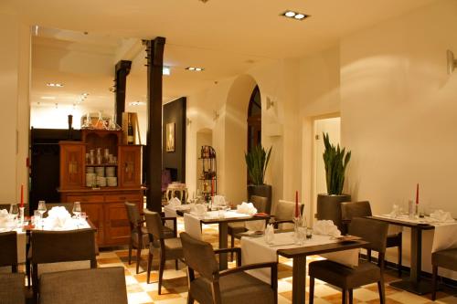 Hotel Gut Landscheid في بورتشيد: مطعم فيه طاولات وكراسي في الغرفة