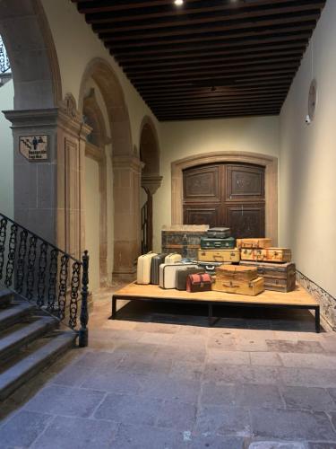 a room with a table with stacks of luggage at Iturbide500 hostal in San Luis Potosí