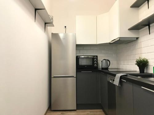 a kitchen with a stainless steel refrigerator and a microwave at Apartament Active Moon in Lublin