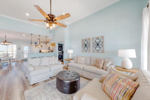 a living room with white furniture and a ceiling fan at Waverly in Dauphin Island