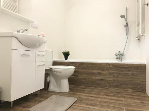 a bathroom with a toilet and a sink and a bath tub at Apartament Active Moon in Lublin