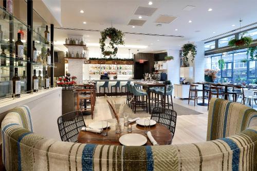 a restaurant with a table and chairs and a bar at INNSiDE by Meliá New York Nomad in New York