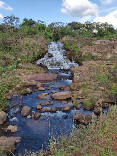 a waterfall on the side of a hill with a creek at Pousada do Canto in Rio Acima