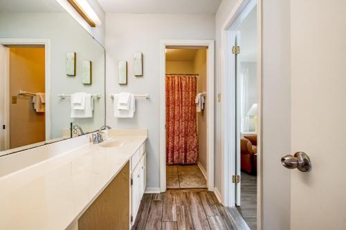 a bathroom with a sink and a large mirror at The Flip Side by Meyer Vacation Rentals in Gulf Shores