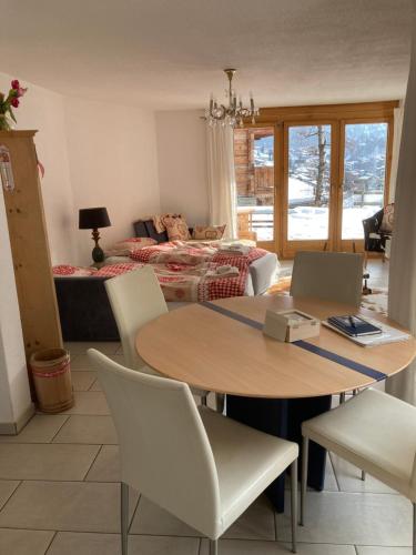 uma sala de estar com uma mesa e cadeiras e uma cama em Millennium em Zermatt