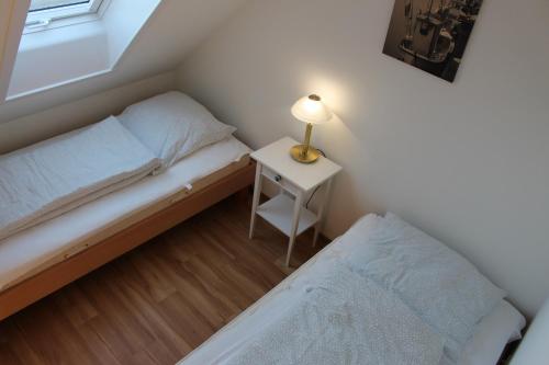 a small bedroom with a bed and a lamp on a table at Ferienwohnung Ostseeglück, Schönberger Strand, Meerblick in Stakendorfer Strand
