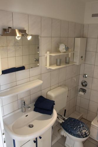 ein Badezimmer mit Waschbecken, Toilette und Spiegel in der Unterkunft Ferienwohnung Ostseeglück, Schönberger Strand, Meerblick in Stakendorfer Strand