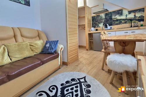 a living room with a couch and a table at Ski Tour Apartments in Zakopane