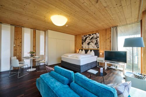 - un salon avec un lit et un canapé bleu dans l'établissement Design Apartment mit Naturblick, à Bregenz