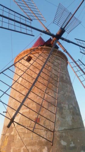 an oldurned windmill with a clear blue at Appartamento L'Ammiraglio in Trapani