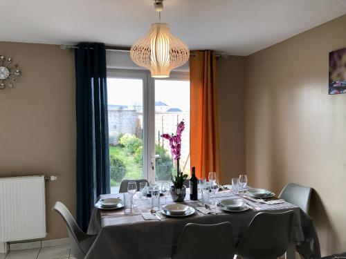 une salle à manger avec une table et une grande fenêtre dans l'établissement Agréable maison proche Gare avec parking gratuit, au Mans