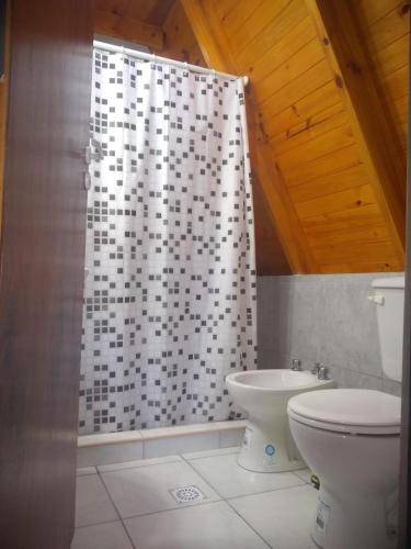 a bathroom with a shower curtain and a toilet at Cabañas :Doña María Nuñez in Gualeguaychú