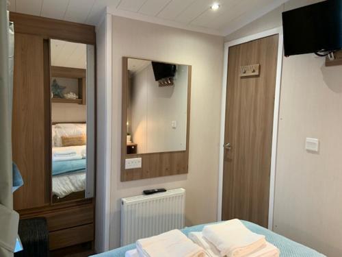 Un pat sau paturi într-o cameră la Cosy, coastal themed Holiday Home, Rockley Park, Poole, Dorset