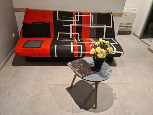 een woonkamer met een bank en een tafel met bloemen bij L'oxygène ardéchois in Ruoms