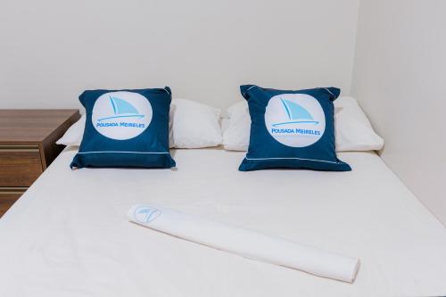 a bed with blue and white pillows on it at Pousada Meireles in Fortaleza