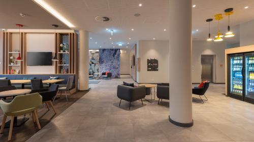 a restaurant with tables and chairs and a lobby at Holiday Inn Express & Suites - Potsdam by IHG in Potsdam
