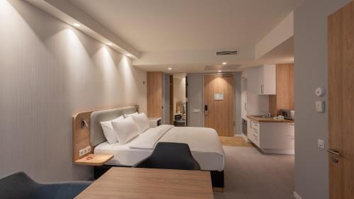a bedroom with a white bed and a kitchen at Holiday Inn Express & Suites - Potsdam by IHG in Potsdam