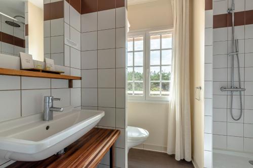 bagno con lavandino, servizi igienici e finestra di Logis Hôtel de L'Océan a Moliets-et-Maa