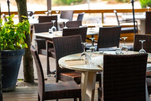 - une rangée de tables et de chaises avec des verres à vin dans l'établissement Logis Hôtel de L'Océan, à Moliets-et-Maa