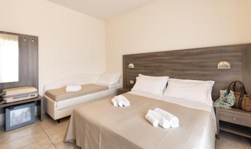 a bedroom with two beds with towels on them at Hotel Edelweiss Riccione in Riccione