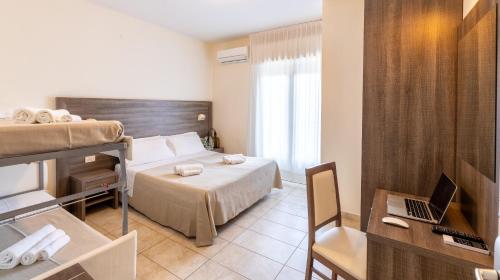 a hotel room with a bed and a laptop on a desk at Hotel Edelweiss Riccione in Riccione