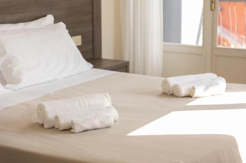 two rolls of towels sitting on a bed at Hotel Edelweiss Riccione in Riccione